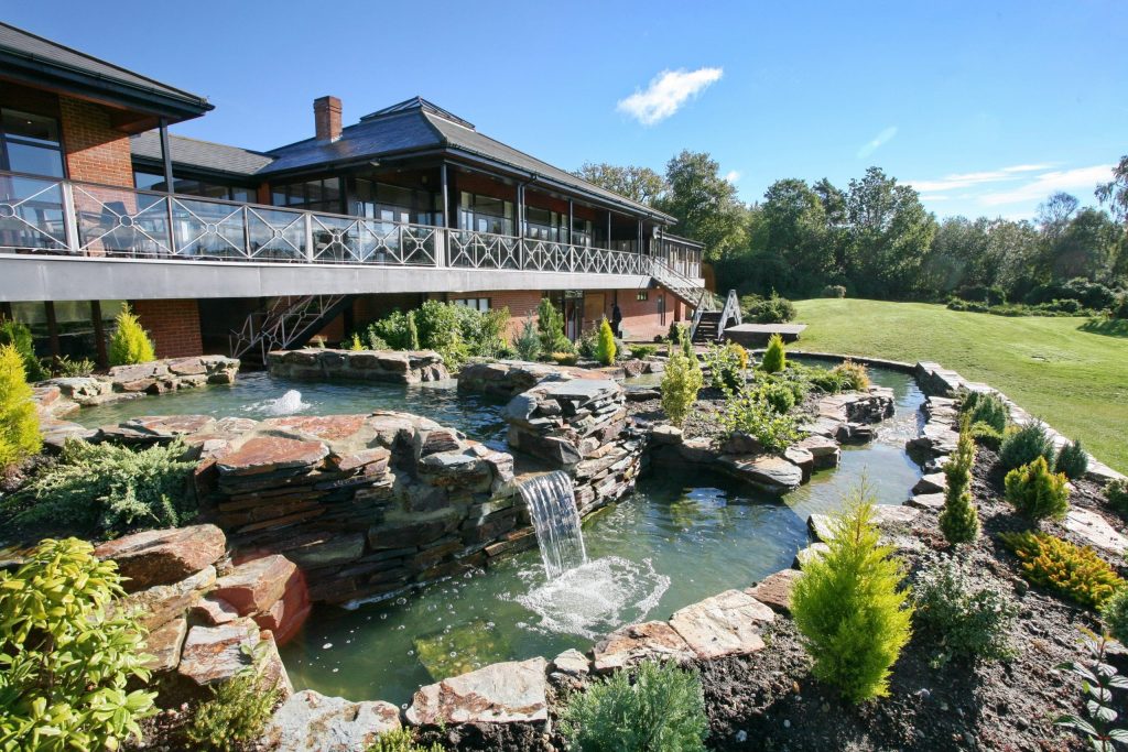 a building with a pond and a waterfall